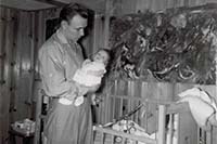 Harlan holding Vicky at crib